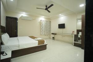 a bedroom with a bed and a ceiling fan at Hotel Jay Palace in Kota +9 photos