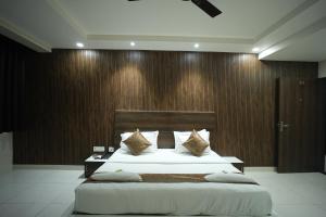 a bedroom with two beds and a wooden wall at Hotel Jay Palace in Kota