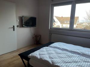 a bedroom with a bed and a tv and a window at Ferienwohnung Fatlume No 3 in Bad Honnef am Rhein +21 photos