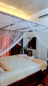 a bedroom with a white bed with a canopy at Turtle Island Cabana in Tangalle