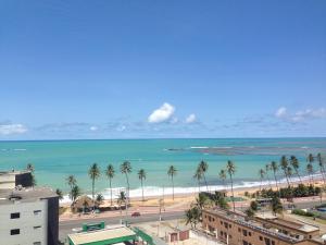 een uitzicht op een strand met palmbomen en de oceaan bij Apartamento Sol e Mar Maceió in Maceió