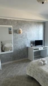 a bedroom with a bed and a desk and a mirror at L'Alba in Tropea
