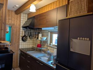 a kitchen with a sink and a black refrigerator at Lakeview Etsu in Lake Toya