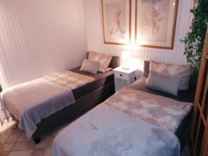 a room with two beds and a table with a lamp at Monteurzimmer Grüner Winkel in Lembruch
