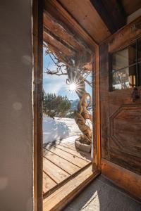 an open door of a house with a tree at Hunters Lodge Chalet Superior in Alpbach