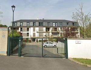 a white car parked in front of a large building at Appartement moderne Senlis in Senlis