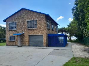 a brick building with a garage at Vaaldamhuis in Oranjeville