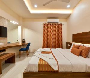 a bedroom with a bed and a desk and a television at Hotel Rajpurush in Kolhapur +52 photos