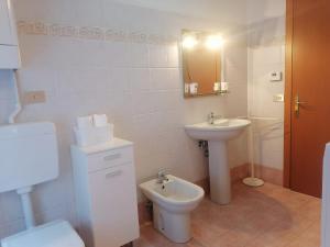 a white bathroom with a sink and a toilet at Casa Fabiola in Longarone