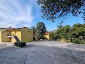 a parking lot with a yellow building at Guest House Morska Grota in Povile