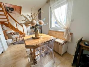 a room with a table with a vase of flowers on it at Écrin Ostwald 2 private suites Free parking in Ostwald