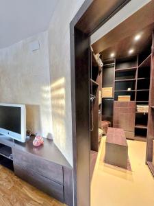 a living room with a tv and a desk with a television at Écrin Ostwald 2 private suites Free parking in Ostwald