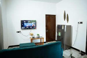 a living room with a blue couch and a refrigerator at Patnem Bliss in Canacona
