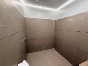 a small bathroom with a toilet in a room at Govindam Palace in Govardhan