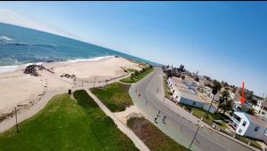 a road next to a beach with the ocean at Sleep to the Sound of Waves - Full Private Apartment in Swakopmund +6 photos