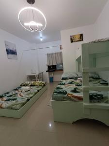 a room with two beds and a light fixture at JCE Comfort & Simplicity in Tacloban