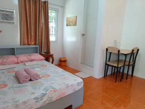 a bedroom with a bed with pink pillows on it at JCE Comfort & Simplicity in Tacloban