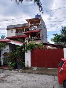 a house with a red fence and a red gate at JCE Comfort & Simplicity in Tacloban