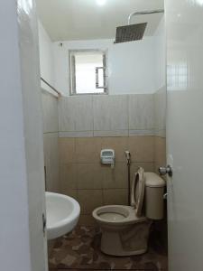 a bathroom with a toilet and a sink at JCE Comfort & Simplicity in Tacloban +48 photos