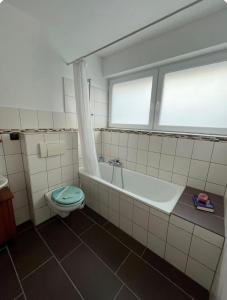 a bathroom with a tub and a toilet and a window at Ferienwohnung Fatlume No 3 in Bad Honnef am Rhein
