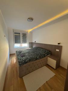 a small bedroom with a bed and a window at Apartman Akademska Četvrt in Čačak