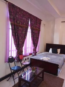 a bedroom with a bed and two chairs and a table at The nest haputale in Haputalegama +1 photo