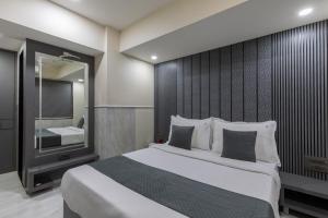 a bedroom with a large bed and a large mirror at Hotel JK Regency, Mumbai International in Mumbai +40 photos