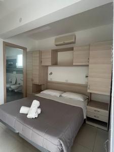 a bedroom with a bed with two towels on it at Villa Marcolini in Cattolica