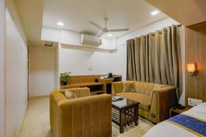 a living room with a couch and chairs in a room at Hotel JK Regency, Mumbai International in Mumbai