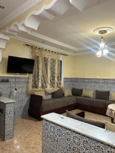 a living room with a couch and a tv at Maison in Berkane