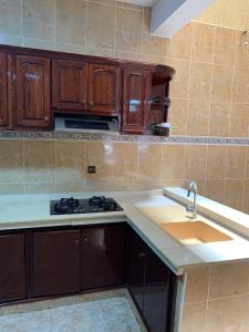 a kitchen with a sink and a stove and cabinets at Maison in Berkane +10 photos