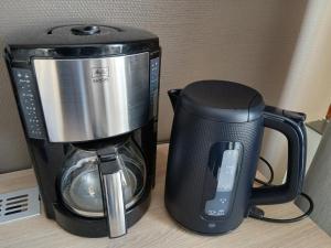 a coffeemaker next to a coffee maker on a counter at Ellivuori, Ellin Pooli2 in Sastamala