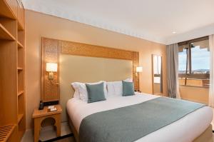 a hotel room with a large bed and a window at Kenzi Azghor in Ouarzazate +45 photos