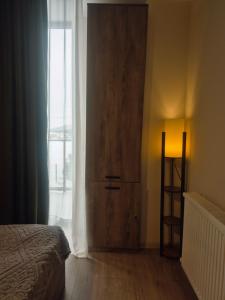 a bedroom with a large wooden door next to a window at Bakuriani Plaza A block N109 in Bakuriani