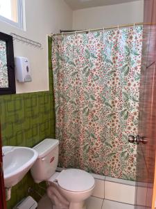 a bathroom with a toilet and a shower curtain at Hostal Villa Franca in Ibarra +23 photos
