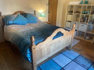 a bedroom with a large bed with blue pillows at Fenland Gallery in Whittlesey +12 photos