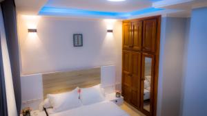 a bedroom with a bed with a blue ceiling at Résidence TB in Douala