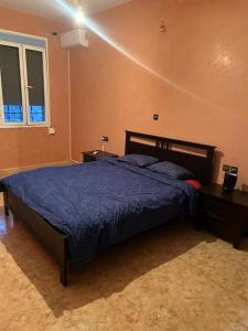 a bedroom with a bed with a blue comforter at Maison in Berkane