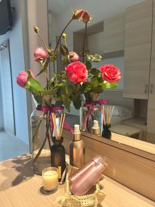 a vase with pink roses and candles on a table at Villa Marcolini in Cattolica