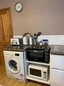 a kitchen with a microwave and a washing machine at ROOM with SHOWER, TOILET and KITCHENETTE in Tonbridge