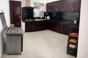 a kitchen with wooden cabinets and a stove top oven at A&J Rest House in Kerawalapitiya