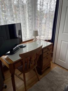 a desk with a computer and a lamp and a window at ROOM with SHOWER, TOILET and KITCHENETTE in Tonbridge