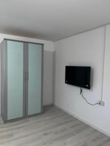 a room with a tv on a white wall at Ferienwohnung Fatlume No 1 in Bad Honnef am Rhein +6 photos