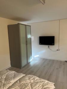 a bedroom with a bed and a tv on the wall at Ferienwohnung Fatlume No 1 in Bad Honnef am Rhein