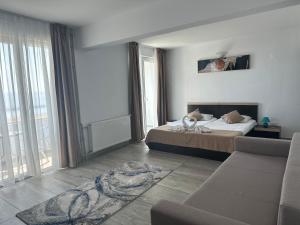 a hotel room with a bed and a couch at Hotel Cosmos in Eforie Sud