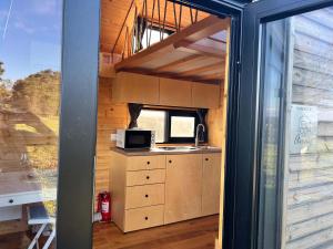 a kitchen in a tiny house with a microwave at Quinta da Runa by Tiny Away in Bagunte +6 photos