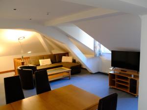 a living room with a couch and a tv at Landhaus Lockwitzgrund in Lockwitz