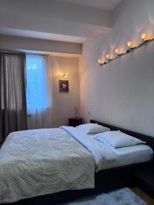 a bedroom with a large bed with a window at Vintage Veranda Apartment in Itʼkhvisi
