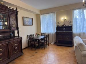 a living room with a table and chairs and a couch at Vintage Veranda Apartment in Itʼkhvisi