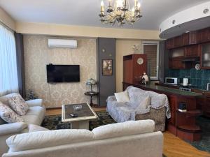 a living room with a couch and a tv at Vintage Veranda Apartment in Itʼkhvisi